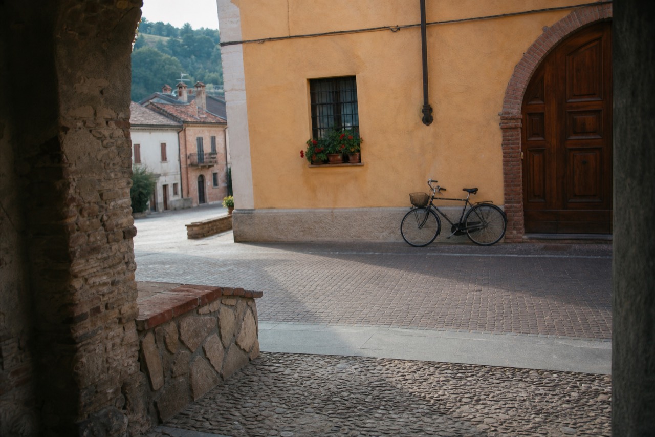 A quiet Monferrato village with a bike on a cobbled street.