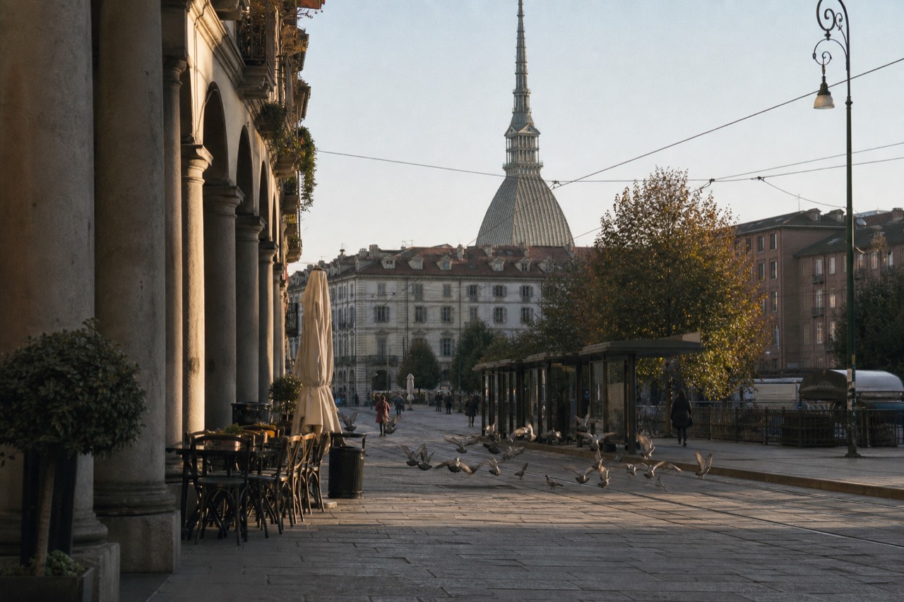 Turin's arcaded central streets with the Mole Antonelliana rising behind the rooftops.