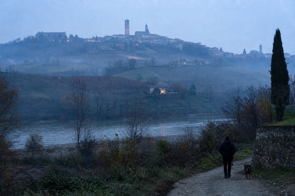 Rolling hills with a bell tower village on the Barbaresco side of the valley.