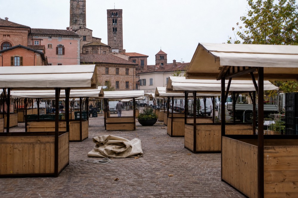 Historic piazza in Alba prepared for the white truffle fair with market stalls.