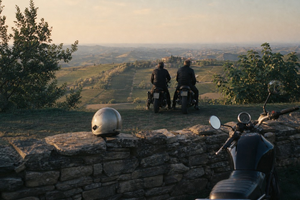 Guided cycling group stopped at a viewpoint above the Barolo hills.