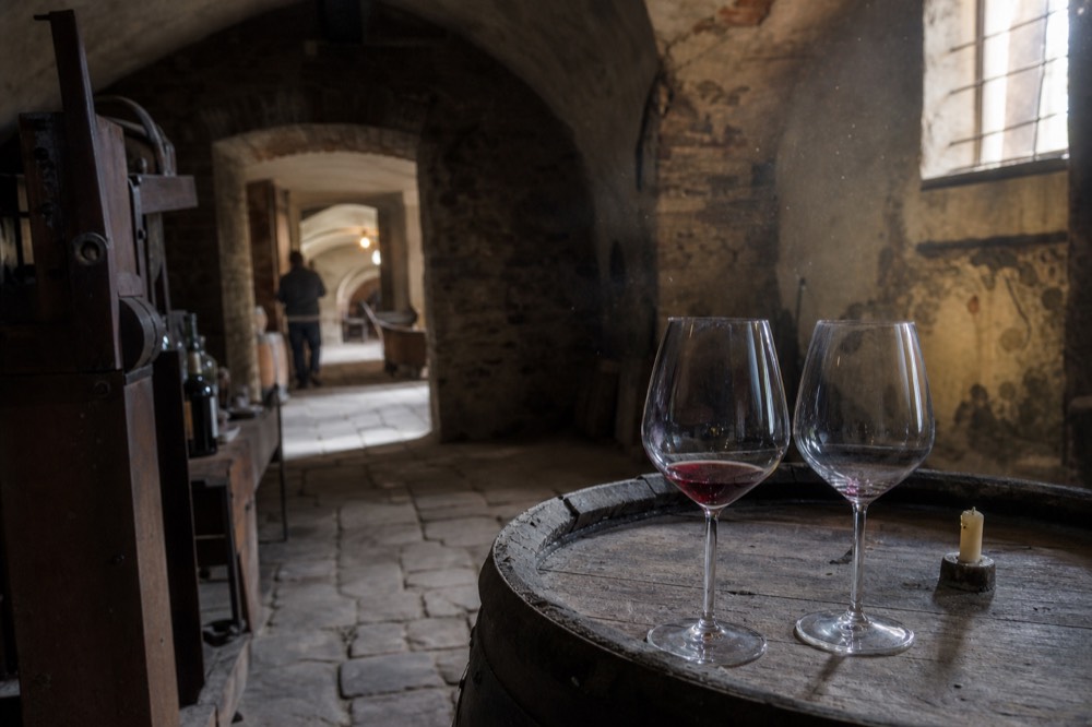 Wine glasses on a barrel in a cellar.